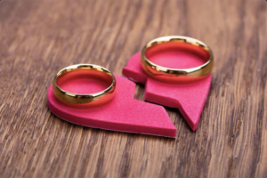 A broken heart on a table with two rings